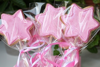 Galletas decoradas varitas mágicas de color rosa.